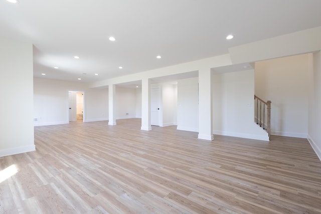 basement with light wood-type flooring, stairs, baseboards, and recessed lighting