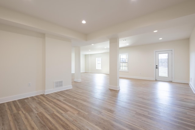 unfurnished room featuring decorative columns, baseboards, visible vents, light wood-style floors, and recessed lighting