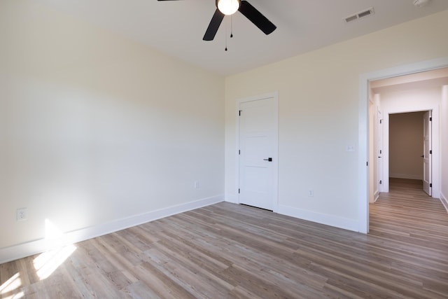 unfurnished bedroom with visible vents, ceiling fan, baseboards, and wood finished floors