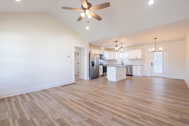 unfurnished living room with lofted ceiling, light wood-style flooring, a sink, baseboards, and ceiling fan with notable chandelier