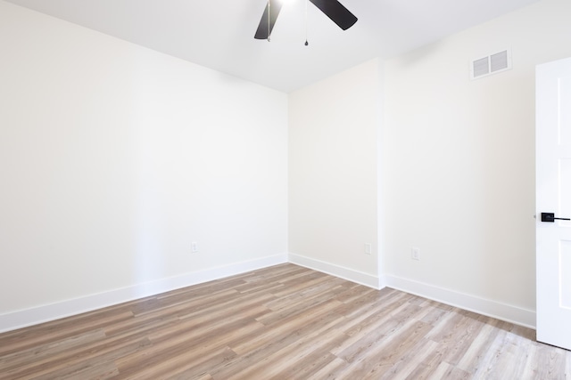 spare room with light wood-style flooring, visible vents, ceiling fan, and baseboards