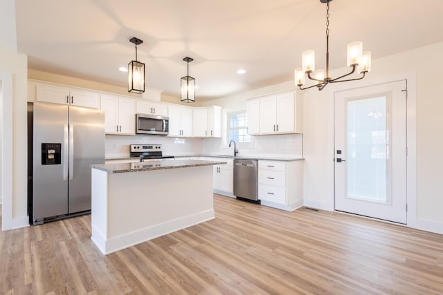 kitchen featuring stainless steel appliances, white cabinets, and light wood-style floors