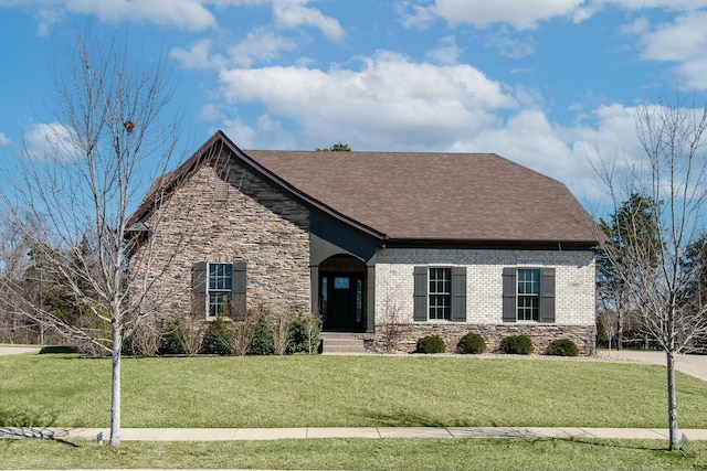 view of front facade with stone siding, brick siding, and a front yard