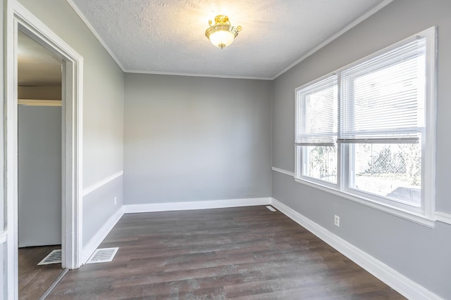 unfurnished room featuring visible vents, dark wood-type flooring, a textured ceiling, crown molding, and baseboards