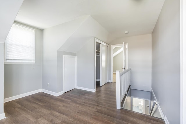 additional living space with dark wood-style floors and baseboards