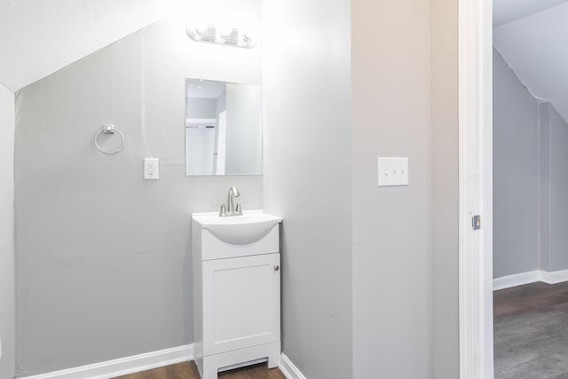 bathroom with vanity, wood finished floors, and baseboards