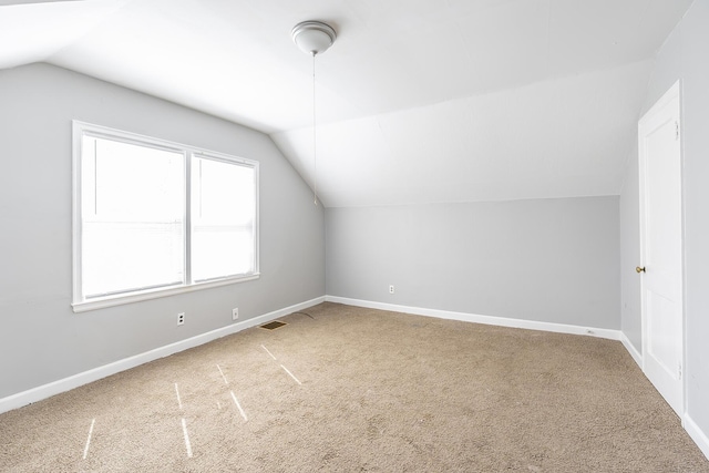 additional living space with carpet, baseboards, and vaulted ceiling