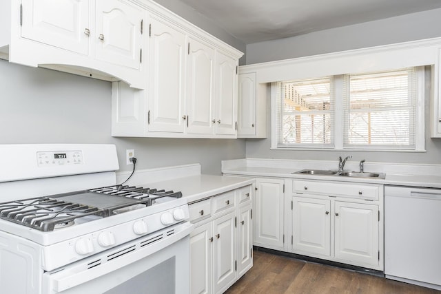 kitchen with white appliances, dark wood-style floors, a sink, light countertops, and white cabinets