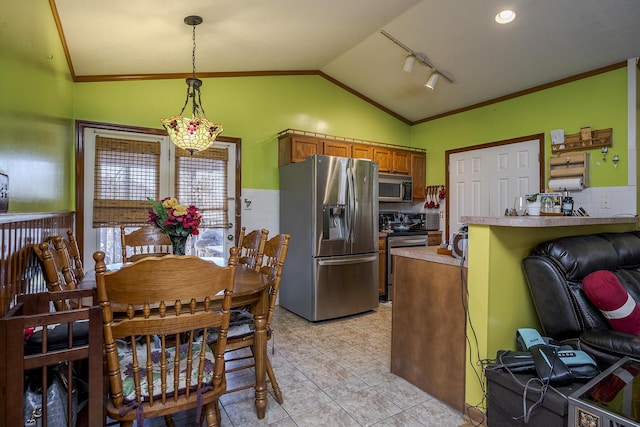 dining room featuring rail lighting, vaulted ceiling, light tile patterned flooring, and ornamental molding