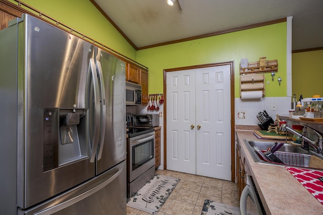 kitchen with a sink, crown molding, tasteful backsplash, and stainless steel appliances