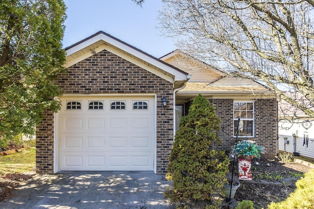 ranch-style house featuring brick siding, driveway, and an attached garage