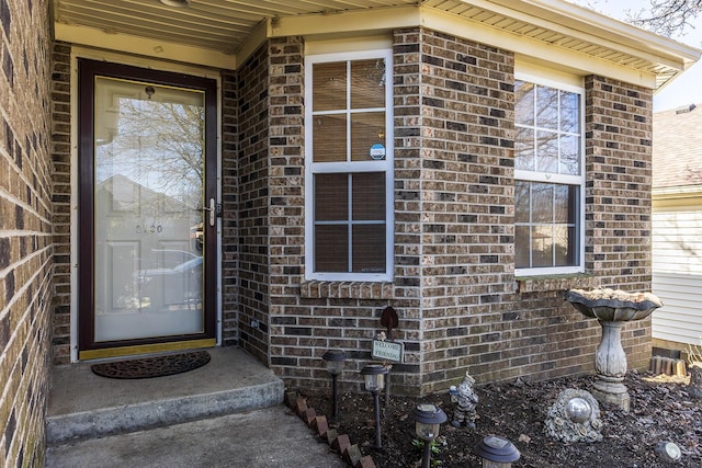 doorway to property featuring brick siding