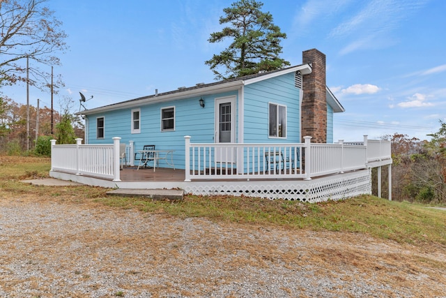 rear view of property with a wooden deck and a chimney