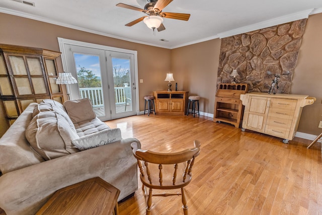 living area featuring a ceiling fan, crown molding, light wood-type flooring, baseboards, and visible vents