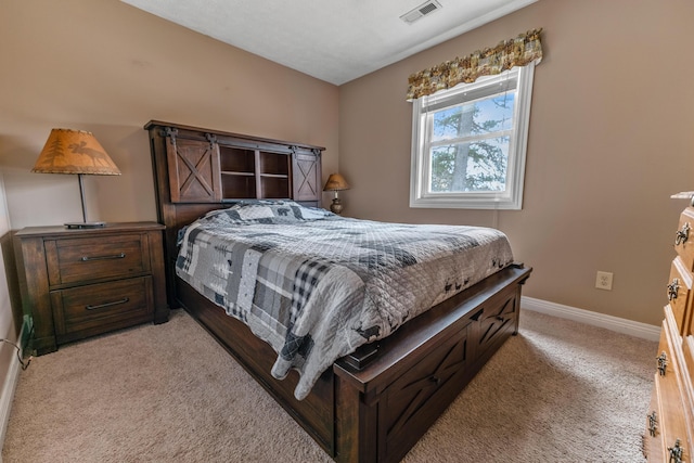 bedroom with baseboards, visible vents, and light colored carpet