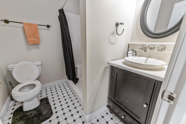 bathroom with tile patterned floors, toilet, baseboards, shower / tub combo with curtain, and vanity