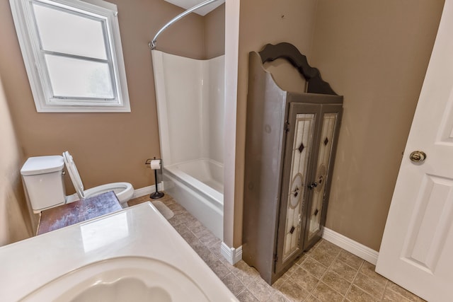 bathroom featuring tub / shower combination, vanity, toilet, and baseboards