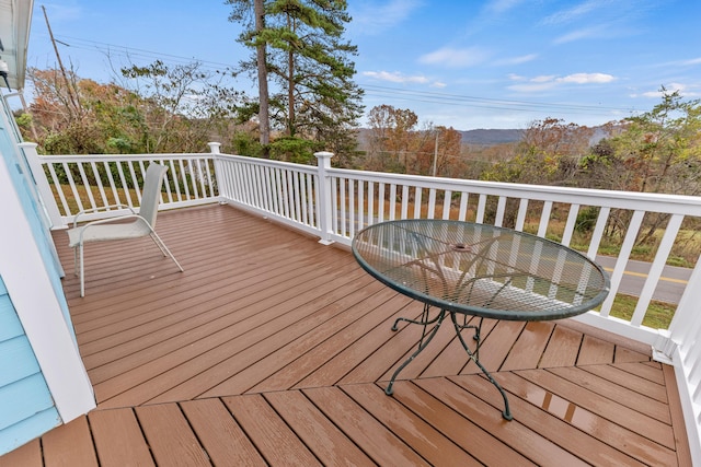 wooden deck with outdoor dining area and a mountain view