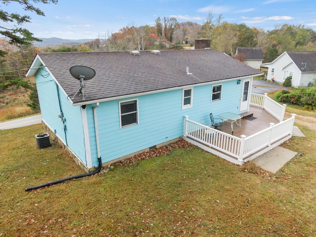 rear view of property with a chimney, central AC unit, a yard, roof with shingles, and a deck