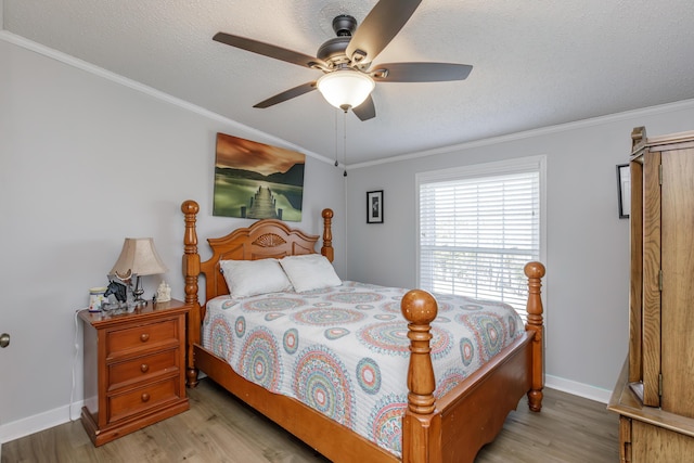 bedroom featuring crown molding, a textured ceiling, baseboards, and wood finished floors