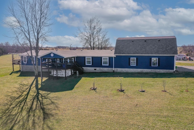 rear view of property with a shingled roof, a lawn, and a deck