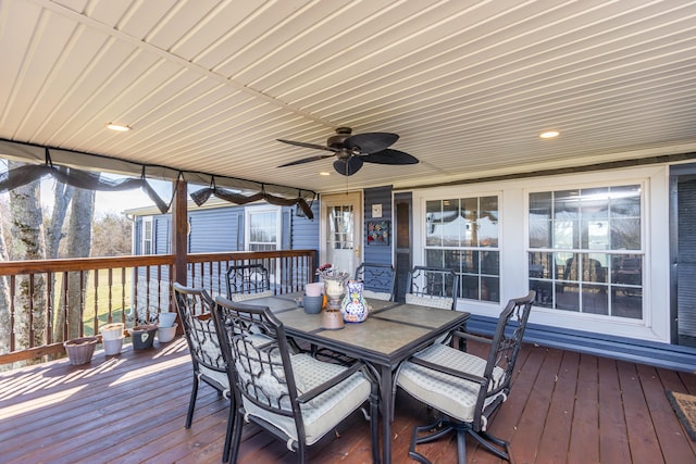 wooden terrace with a ceiling fan and outdoor dining space