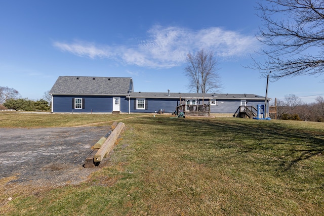 rear view of property featuring a lawn and a wooden deck