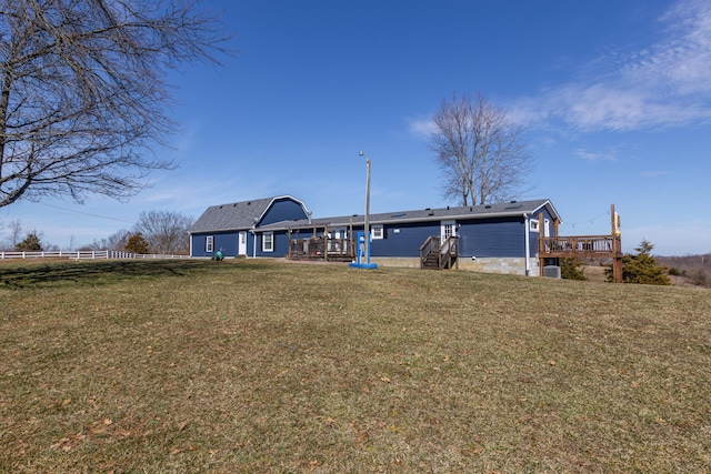 rear view of property featuring a yard and fence