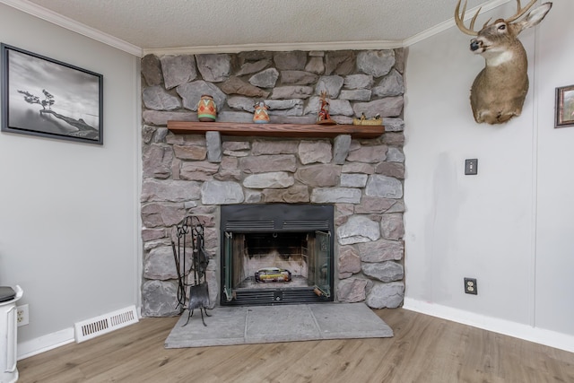 interior details with a fireplace, visible vents, wood finished floors, and ornamental molding