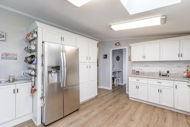 kitchen with white cabinets, crown molding, light wood-style flooring, and stainless steel fridge with ice dispenser