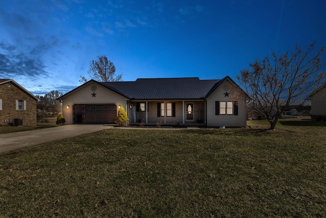 single story home featuring driveway, a garage, metal roof, and a lawn