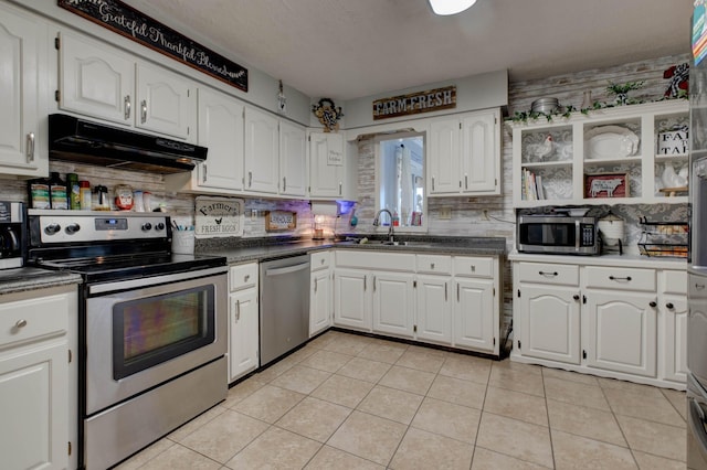 kitchen with under cabinet range hood, stainless steel appliances, a sink, white cabinetry, and decorative backsplash