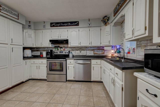 kitchen featuring light tile patterned floors, extractor fan, stainless steel appliances, white cabinetry, and a sink