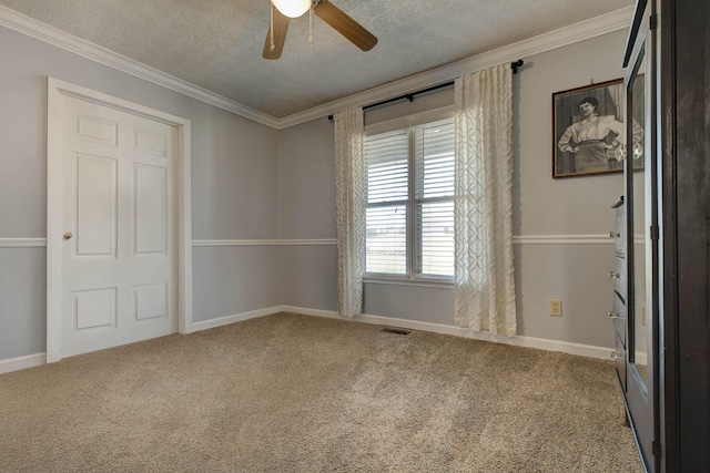 empty room featuring carpet floors, crown molding, and a textured ceiling