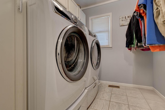 laundry area with light tile patterned flooring, visible vents, baseboards, independent washer and dryer, and cabinet space