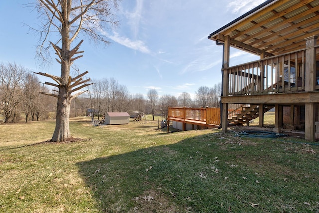 view of yard with stairway, a wooden deck, a shed, and an outdoor structure