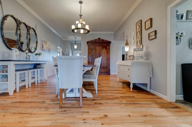 dining room with light wood finished floors, a notable chandelier, baseboards, and crown molding