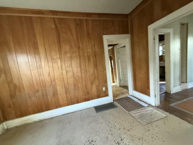 empty room with wood walls and visible vents