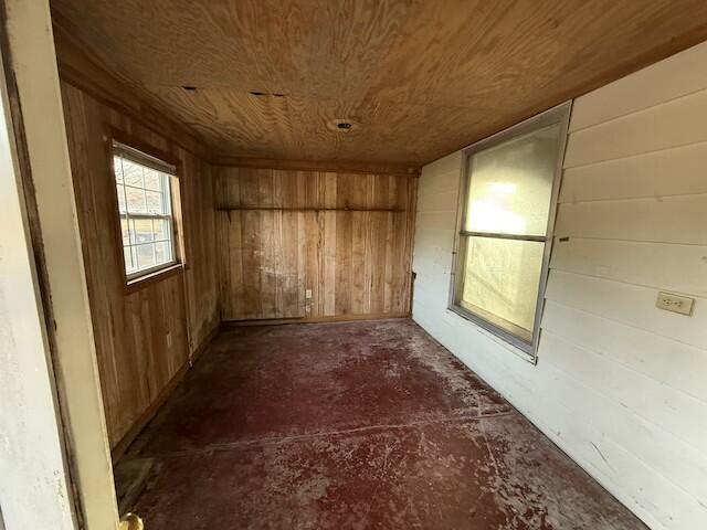 interior space featuring wood ceiling and wooden walls