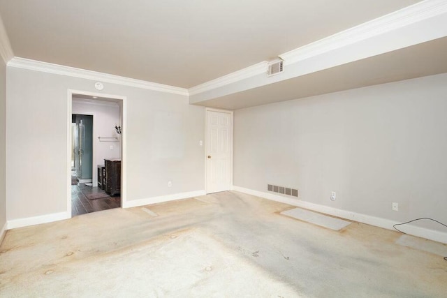 carpeted empty room featuring ornamental molding, visible vents, and baseboards