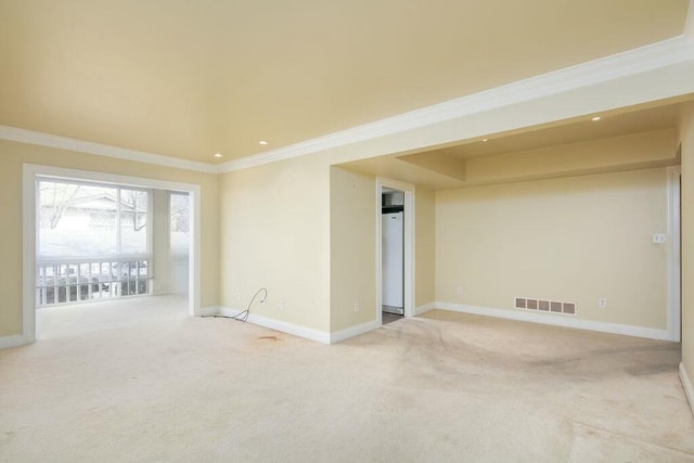 empty room featuring baseboards, visible vents, and light colored carpet