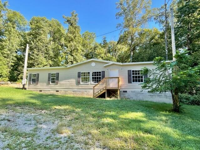 back of house featuring crawl space and a lawn