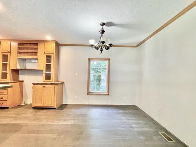 interior space with visible vents, light wood-style flooring, crown molding, a textured ceiling, and a chandelier