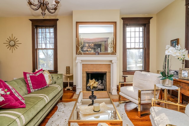 living area with a healthy amount of sunlight, a fireplace, and wood finished floors