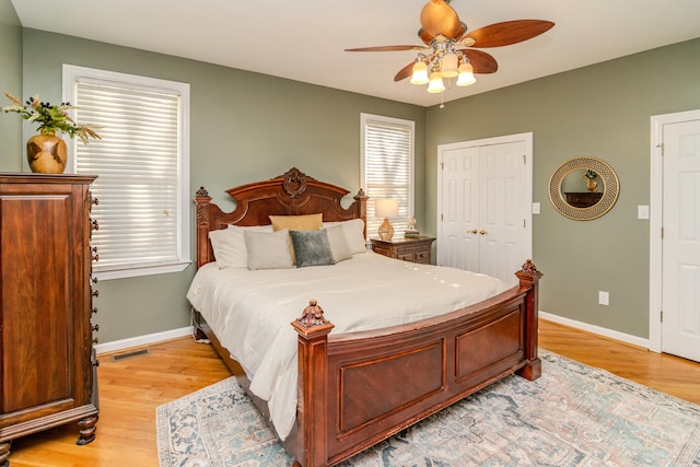 bedroom with baseboards, ceiling fan, visible vents, and light wood finished floors