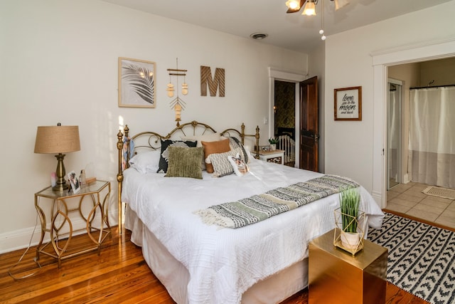 bedroom featuring baseboards, visible vents, and wood finished floors