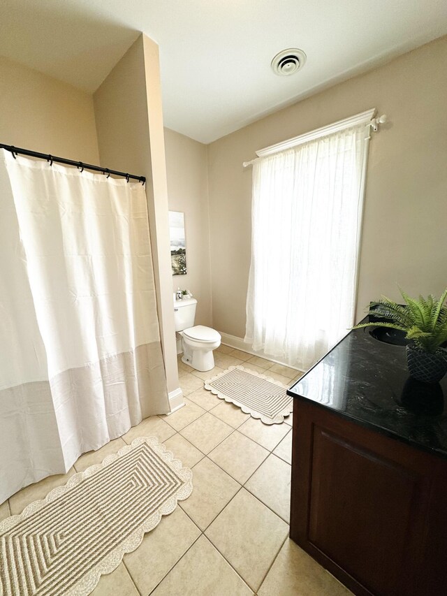 bathroom featuring toilet, a shower with shower curtain, tile patterned flooring, and visible vents