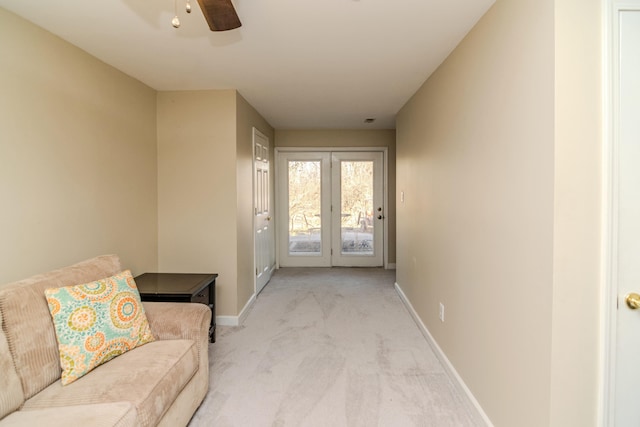 entryway featuring light carpet, ceiling fan, and baseboards