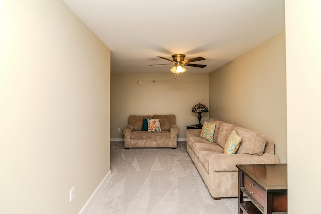 living area with light carpet, ceiling fan, and baseboards