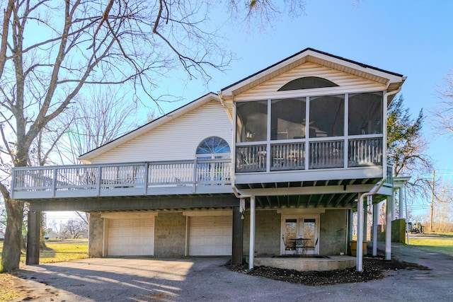 view of front of property featuring a garage, driveway, and a sunroom